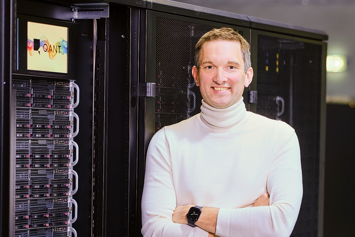 Michael Förtsch, founder and CEO of photonic processing company Q.ANT, standing in front of a data center server rack.