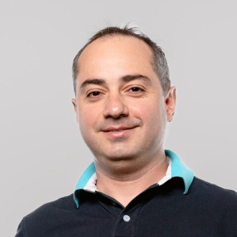 Headshot portrait of Armenian-American entrepreneur Mikayel Vardanyan, co-founder of Picsart, in front of a grey studio background.