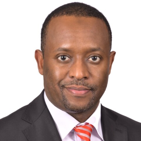 Headshot portrait of Dr. Mustafa Y. Ali, Executive Director of Arigatou International, in front of a white background.