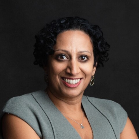 Headshot portrait of Nina Zimmermann, CEO of kununu, brightly lit in front of a dark studio background.