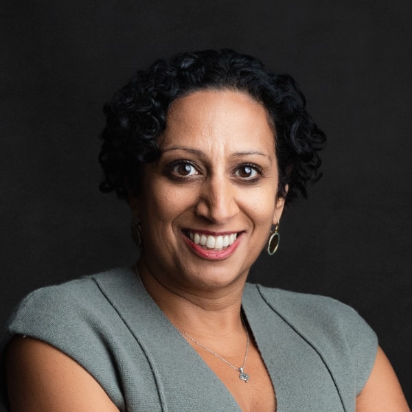 Headshot portrait of Nina Zimmermann, CEO of kununu, brightly lit in front of a dark studio background.