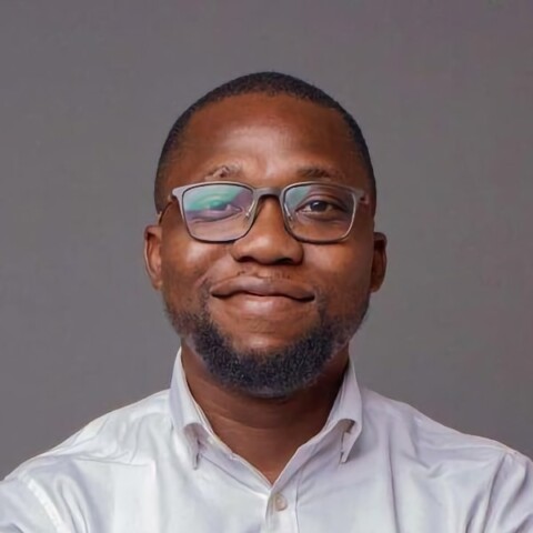 Studio portrait of Oluwajoba Oloba, co-founder of The Nest Innovation Hub, in front of a grey studio background.