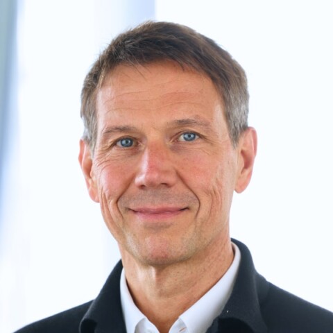 Headshot portrait of investor and board member René Obermann, Warburg Pincus, in front of a light grey background.