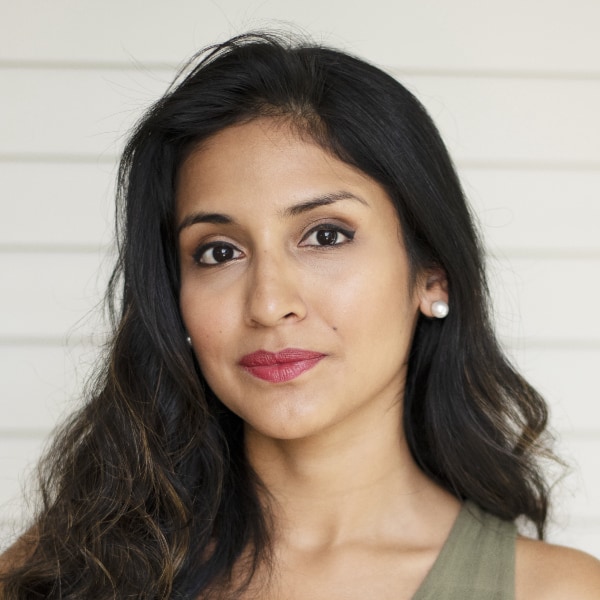 Headshot portrait of nature conservationist Dr. Rosa Vásquez Espinoza, Founder and Executive Director of Amazon Research Internacional, in front of a striped grey wall.