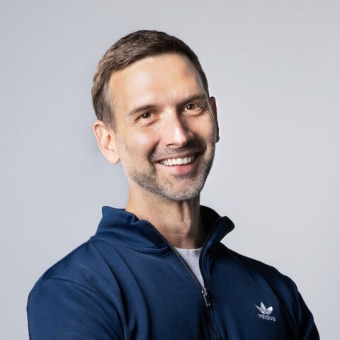 Portrait of adidas CDO Tobias Seemann in front of a grey studio background.