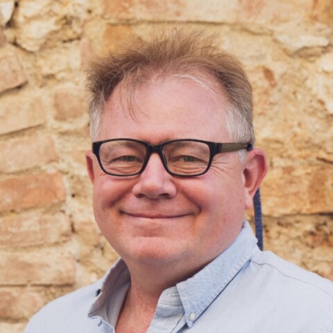 Profile image of energy consultant Tony Pink, standing in front of a yellow-brown brick wall.