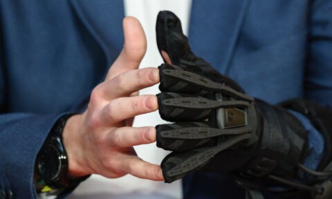 Close-up of Ryan Alicea (Powered Orthotics) wearing a MotionMate robotic hand at the DLD Munich 2026 conference.