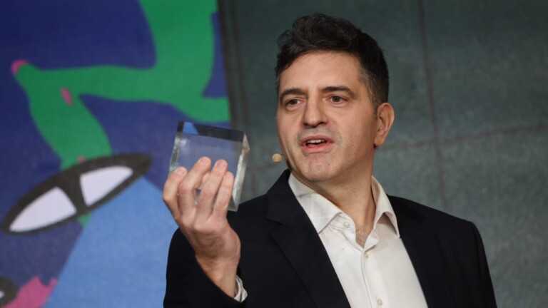 Alexander Stojanovic, founder of the DARI Foundation, unveils the Tesseract project at the DLD Munich 2026 conference, holding a memocube in his hand.