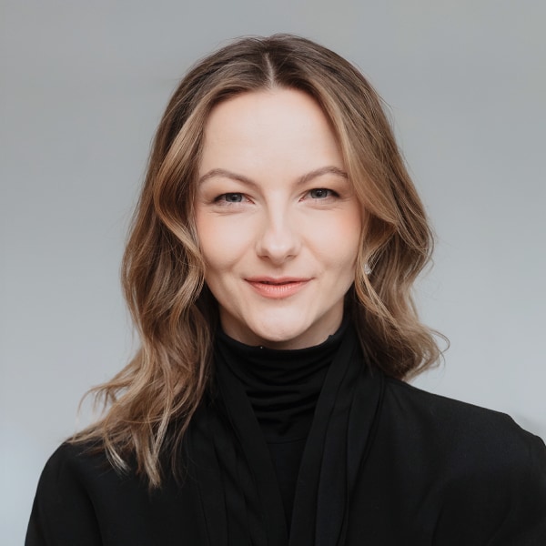 Headshot portrait of Alessia Sinzger, co-CEO, DLD conferences, in front of a grey studio background
