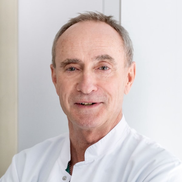 Portrait of neurosurgeon and BCI specialist Prof. Dr. Bernhard Meyer, TUM, in front of a grey background