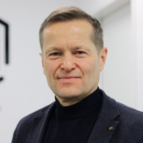 Headshot portrait of physicist Ferenc Krausz (Max Planck, LMU) in front of a grey wall