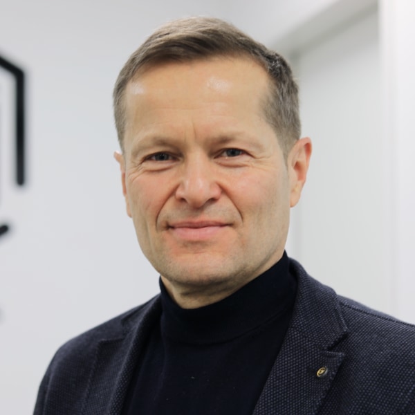 Headshot portrait of physicist Ferenc Krausz (Max Planck, LMU) in front of a grey wall