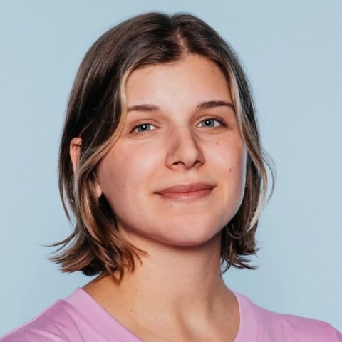Headshot portrait of German journalist Janne Knödler in front of a light blue studio background