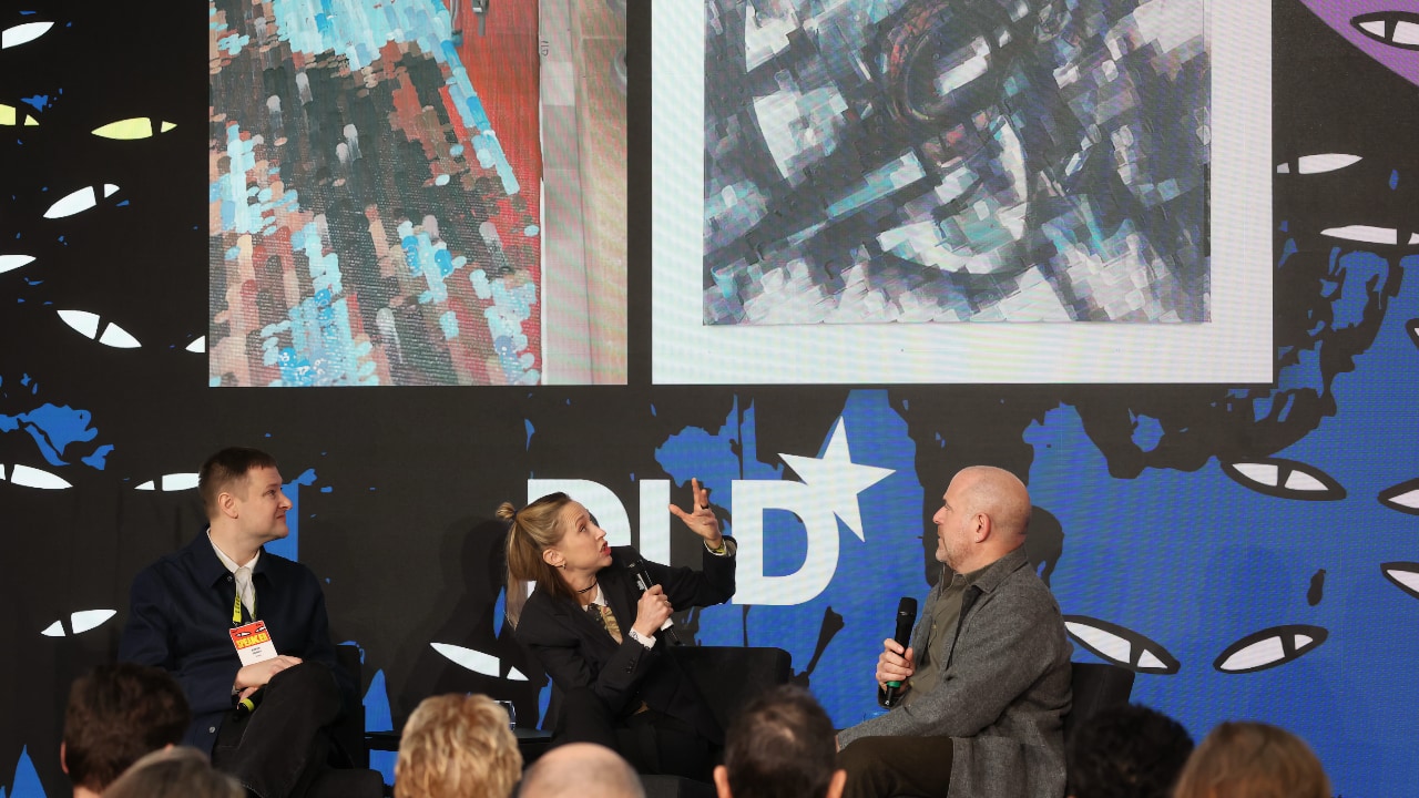 Left to right: Simon Denny (Artist), Caroline Busta (New Models) and Marc Spiegler (Cultural Strategist) on stage at the DLD Munich 2026 conference. Photo: Karl-Josef Hildenbrand / picture alliance for DLD / Hubert Burda Media