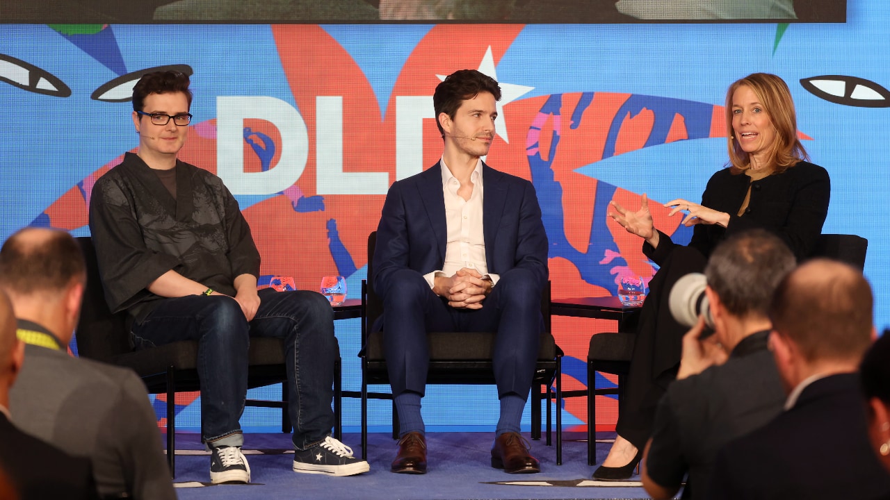 Left to right: Llion Jones (Sakana AI), Rapha&euml;l Milli&egrave;re (University of Oxford) and Ulrike Hoffmann-Burchardi (UBS) speaking at the DLD Munich Conference 2026. Photo: Karl-Josef Hildenbrand / picture alliance for DLD / Hubert Burda Media