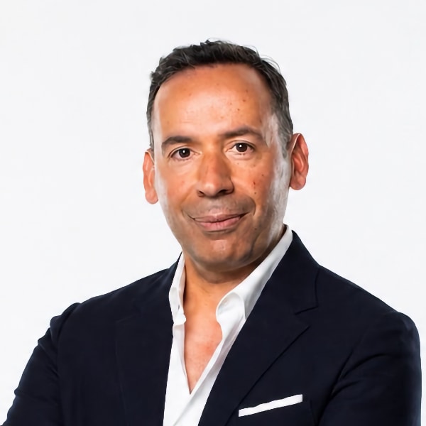 Studio portrait of sports and media manager Luis Vicente in front of a white background