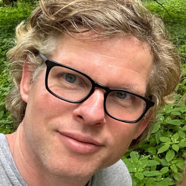 Headshot portrait of Earli CEO Cyriac Roeding, wearing black-rimmed glasses, smiling at the camera.